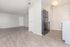 Modern apartment interior showcasing sleek hardwood floors, an open living space, and contemporary kitchen with stainless steel appliances.