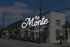 Charming The Monte Boutique Apartments with a vintage exterior, framed by lush palm trees and a sunny blue sky backdrop.