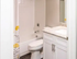 Bright and modern bathroom with elegant granite countertop and floral accented shower curtain.