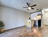 Modern apartment kitchen with sleek white cabinets, stylish laminate flooring, and chic breakfast bar featuring yellow stools.