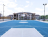 Inviting apartment complex with modern architecture overlooking a vibrant blue basketball court, perfect for sports enthusiasts and active lifestyles.