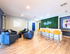 Modern apartment lobby with stylish blue seating area, vibrant greenery wall, and sleek wooden flooring at The Iris.