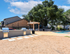 Inviting outdoor space with modern grills, poolside lounge chairs, and lush greenery, perfect for relaxation.