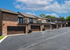 Charming townhouse row showcasing elegant brick facades with spacious garages and balconies, set against a clear blue sky.