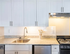 Elegant kitchen featuring modern appliances, sleek granite countertops, and bright white cabinetry.