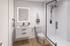 Modern bathroom with sleek vanity, illuminated mirror, and spacious glass shower, perfect for contemporary living.