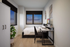 Cozy bedroom with modern decor, featuring a sleek desk setup and stunning window views. Ideal for comfort and productivity.