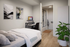 Modern bedroom with cozy bed, stylish artwork, ergonomic workspace, and in-room bathroom for convenience.
