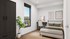 Bright and modern bedroom with chic decor, large window, and stylish workspace overlooking lush greenery.