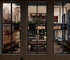 Vibrant apartment common area featuring floor-to-ceiling windows showcasing a stylish lounge with sports-themed decor, multiple TVs, modern seating, and a pool table for entertainment.