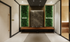 Luxurious spa entrance with vibrant green walls labeled 'refresh' and 'recharge,' featuring a modern wooden bench and ambient lighting.
