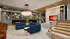 Elegant apartment lobby featuring a modern blue sectional sofa, stylish chandeliers, and cozy seating areas.