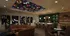 Chic and modern lounge area with vibrant ceiling art, cozy seating, and a stylish bar.