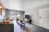 Inviting living room with modern decor, featuring a comfortable sofa, chic armchair, and elegant coffee table, open to a bright sliding glass door with natural light.
