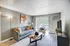 Charming living room with elegant decor, featuring a cozy sofa, accent chair, and natural light streaming through vertical blinds.