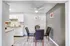 Charming dining area with a modern glass table, plush black chairs, and adjacent stylish kitchen, perfect for cozy gatherings.