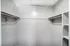 Spacious and bright walk-in closet with ample shelving and hanging space, perfect for organizing your wardrobe luxuriously.