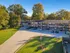 Charming apartment complex amidst lush greenery, featuring ample parking and a peaceful residential setting.