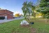 Charming outdoor space with a picnic table and barbecue grill, set in a peaceful grassy area with a picket fence, perfect for relaxation and gatherings.