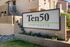 Charming exterior view of Ten50 Apartments with inviting signage and lush landscaping.