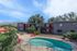 Charming apartment complex with a refreshing pool, stylish architecture, and scenic mountain backdrop.