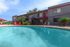 Inviting apartment complex with a refreshing outdoor pool, surrounded by lush greenery and modern architecture.
