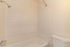 Bright and clean bathroom featuring a classic white tile shower and modern fixtures.