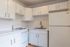 Charming kitchen with sleek white cabinetry, modern appliances, and elegant countertops, perfect for gourmet cooking.