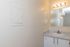 Bright and modern bathroom featuring a sleek countertop, stylish lighting, and a large mirror for a refined look.