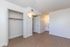 Bright and airy bedroom with sleek wood flooring, open closet space, and access to an adjacent bathroom, perfect for modern living.