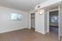 Bright and inviting bedroom with large window, natural light, and sleek wooden floors, perfect for modern living.