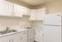 Bright and inviting kitchen with modern white cabinetry, sleek countertops, and essential appliances.