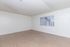 Bright and spacious living area with modern wooden flooring, large window with vertical blinds providing ample natural light.
