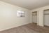 Bright and airy bedroom with soft carpet, ample closet space, and a window providing natural light, perfect for a cozy retreat.