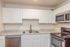Modern kitchen with sleek stainless steel appliances, elegant marble countertops, and pristine white cabinetry.