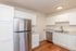 Modern kitchen with sleek stainless steel appliances, crisp white cabinetry, and elegant wooden flooring.