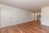 Inviting apartment interior showcasing elegant wood flooring, modern kitchen with stainless steel appliances, and spacious open-concept living area.