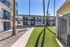 Charming apartment complex with modern balconies overlooking a lush courtyard, perfect for vibrant community living.