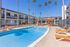Inviting apartment complex pool area with bright orange lounge chairs, elegant palm trees, and shaded seating under vibrant umbrellas.