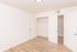 Bright and airy room with sleek laminate flooring and spacious dual closets, perfect for stylish living.