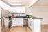 Modern kitchen with sleek stainless steel appliances, elegant white cabinetry, and a spacious countertop perfect for culinary creativity.