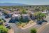 Aerial view of charming residential complex with red-tiled roofs and lush landscaping, offering scenic mountain vistas.