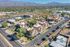 Aerial view of a vibrant neighborhood with charming red-roofed apartments surrounded by lush greenery and mountain vistas.