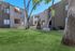 Charming residential complex with lush green lawns, a serene park bench, and modern architectural design.