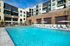 Luxurious apartment complex with a stunning outdoor pool, surrounded by elegant sun loungers and stylish architecture.