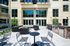Modern outdoor patio with elegant seating, stylish tables, and a premium barbecue grill, perfect for entertaining.