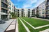 Modern apartment complex featuring lush landscaped courtyard, outdoor seating, and contemporary architecture.
