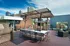 Rooftop terrace with modern pergola, stylish outdoor dining area, and city skyline views, perfect for entertaining.