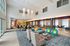 Spacious and elegantly designed apartment common area featuring modern seating with vibrant accents, stylish lighting, and ample natural light.