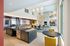 Luxurious modern living space featuring an open-concept design with a sleek kitchen island, stylish dining area, contemporary decor, and expansive windows allowing abundant natural light.